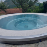Spa rond à débordement avec buses de massage et finition inox, installation réalisée par Dodin Piscine.