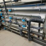 Installation complète du réseau hydraulique d’une piscine avec tuyauterie, vannes et raccords professionnels réalisée par Dodin Piscine